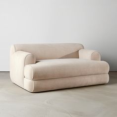 a couch sitting on top of a wooden floor next to a white wall in an empty room