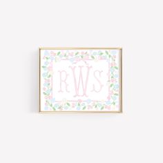 a pink and blue floral frame with the letter rw's on it, in front of a white wall