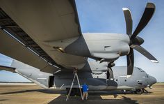 a man standing next to an airplane on top of a tarmac at an airport