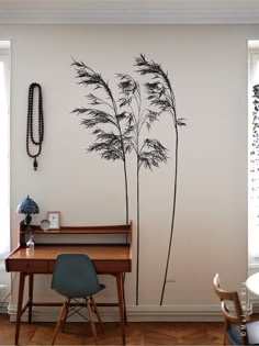 a wall with some plants on it and a table in front of it next to a window