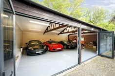 three cars are parked in the garage with their doors open and one car is on the other side