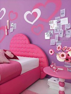 a pink and white bedroom with hearts on the wall