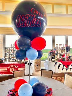 some balloons are sitting on top of a table in a room with tables and chairs