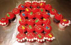 cupcakes with red frosting and decorations on them are arranged in the shape of a dragon