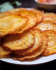 a white plate topped with fried potatoes on top of a table