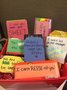 a red basket filled with lots of different types of candy and notes on the side