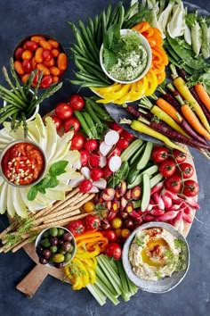 a platter filled with assorted vegetables and dips