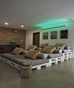 a room with couches made out of pallets and some yellow pillows on them