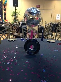 a disco ball sitting on top of a table covered in confetti