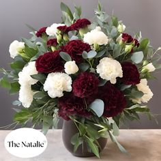 a vase filled with white and red flowers