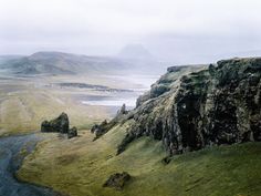 an aerial view of a valley with mountains in the distance and water running through it