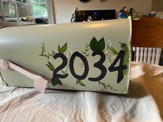 a mailbox with the number 2054 painted on it sitting on a bed in a house