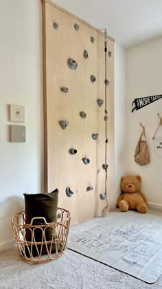 a room with a bed, teddy bear and wall decorations