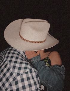 a man wearing a white cowboy hat with his arms wrapped around his neck and chest