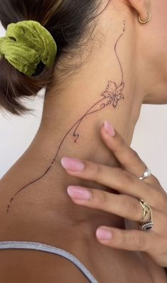 a woman with a flower tattoo on her neck