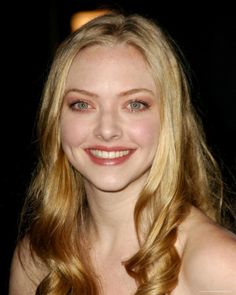 a woman with long blonde hair smiling at the camera