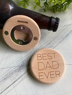 two bottle openers with the words best dad ever engraved on them next to a wine bottle