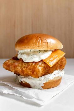 a chicken sandwich with cheese and sauce on it