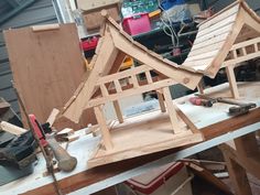 a wooden model of a house being built on a workbench in a workshop