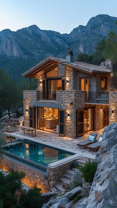 a house with a pool in front of it and mountains in the background at night