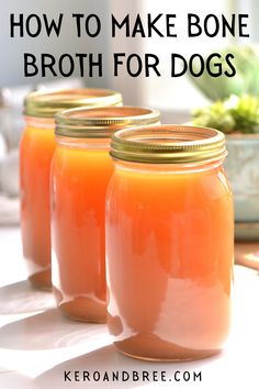 three jars filled with orange liquid sitting on top of a table