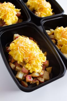 four black trays filled with breakfast foods on top of a white tablecloth and text overlay reads breakfast bowls