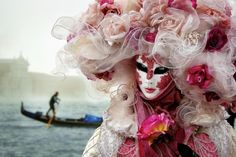 a woman with makeup and flowers on her head standing in front of a gondola