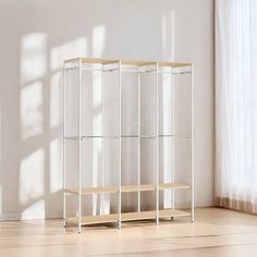 a white shelf with glass shelves in an empty room