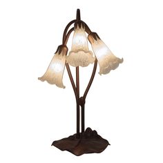 a lamp that is on top of a wooden base and has three flowers in it