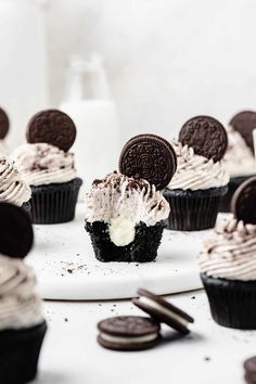 chocolate cupcakes with oreo cookies and cream frosting on a white plate