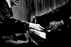 a black and white photo of a man playing the piano