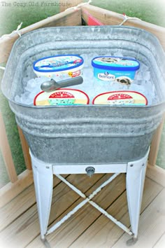 an ice chest is filled with frozen yogurt and other toppings on a wooden deck