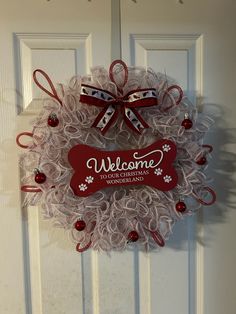 a red and white wreath with the words welcome to your christmas dog on it's front door