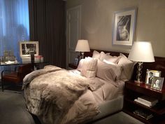 a bedroom with a bed, nightstands and pictures on the wall