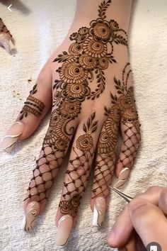 someone is getting their hands painted with henna