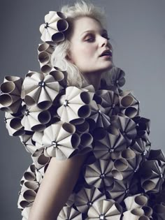 a woman with white hair is dressed up like an origami flower