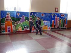 a person standing in front of a painting on the wall next to a checkered floor