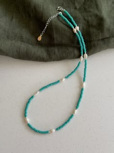 a blue beaded necklace on a white surface