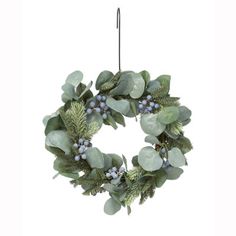 a wreath hanging from the ceiling with greenery and berries on it, against a white background