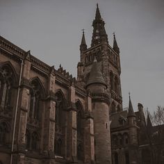 an old building with a clock tower on the front and side of it in black and white