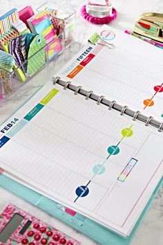 a binder, pen, and paper on a table with other items in the background