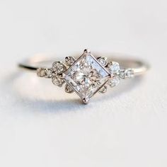 a white gold ring with three princess cut diamonds