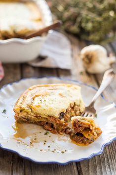 a piece of lasagna on a plate with a fork in front of it