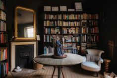 a living room filled with lots of books and furniture