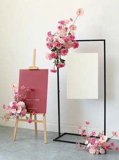 a easel with pink flowers on it next to a blank board and easel