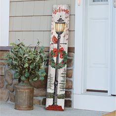 a wooden sign sitting on the side of a building next to a potted plant