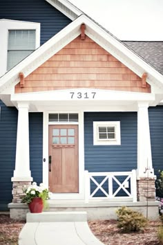 a blue house with white trim and brown door