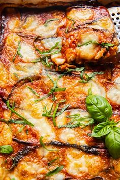 a close up of a pizza with cheese and herbs on it's crusts