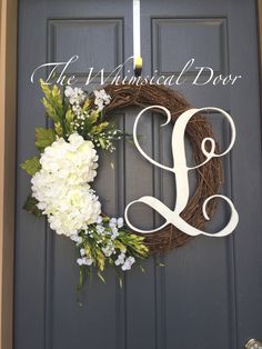 the front door is decorated with a wreath and white hydranges, which are hanging on