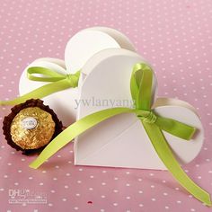 a white box with a green ribbon around it and some chocolates in the front